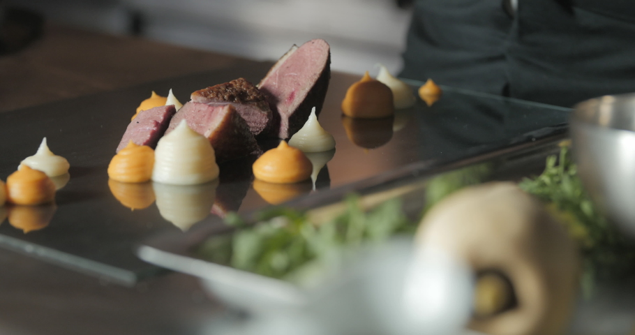 Chef is finishing a gourmet meal, teasty duck breast, beautiful plate, colorful plate, 
French chef cooking a duck breast in a 
Gastronomic restaurant | Shutterstock HD Video #1033275287