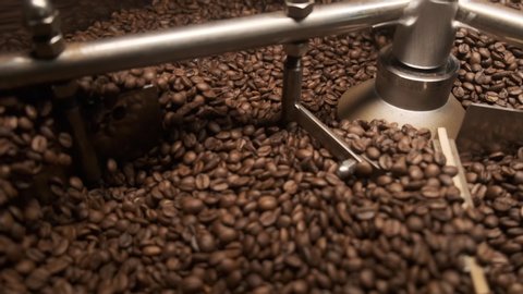 Fresh Coffee Beans - Freshly roasted 100% Arabica coffee beans falling into a spinning cooler professional machine. Mixing roasted coffee. Video stock