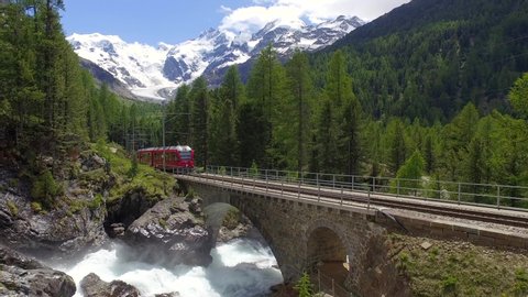 Bernina Express, red train of Bernina and glacier of Morteratsch in the Swiss Alps. Unesco World Heritage