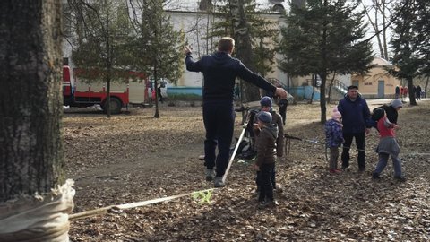 BOBRUISK, BELARUS 03.09.19: Peopole enjoy the celebration of the beginning of Spring. A man goes on a tightrope. Children enjoy a holiday. Kids watch a little show.