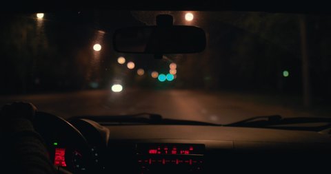 A man driving a car in the night city.