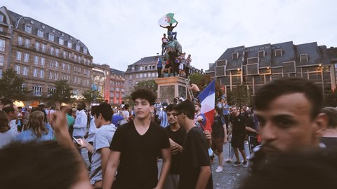 STRASBOURG, FRANCE - JULY 15, 2018: Algerian French Flag waving Statue Happiness and jubilation of supporters after the victory of the French team in the final of the World Cup football in Russia