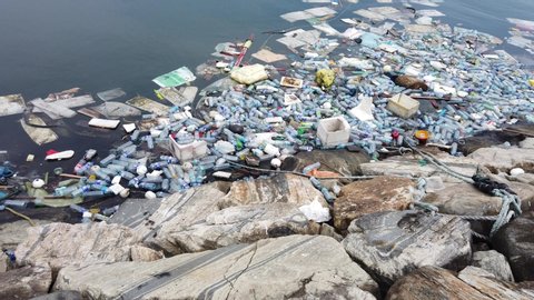 Plastic pollution trash in ocean with different kinds of garbage - plastic bottles, bags, wastes floating in water. Sea ocean water pollution concept. Plastic pollution crisis
