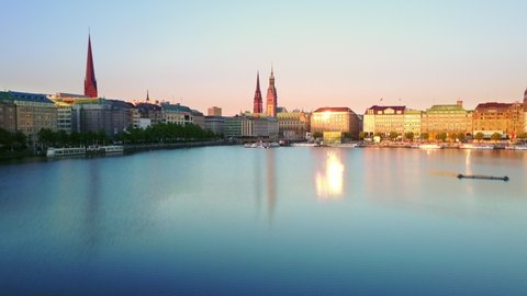 hamburg aerial view at sunrise drone flying low over alster lake rising up over city skyline reveal shot