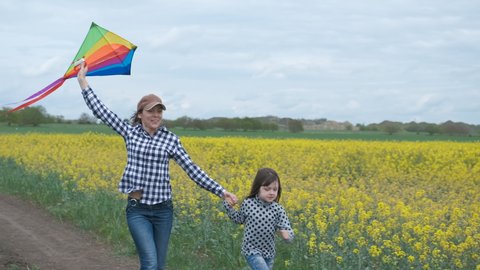 Family with a kite. Happy mother with her daughter with a kite in the field.