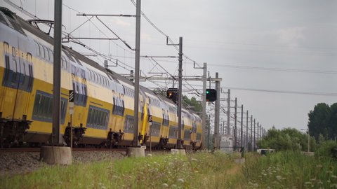 Dutch Double Decker train passes in high speed near Hilversum and Utrecht on a sunny day: film stockowy