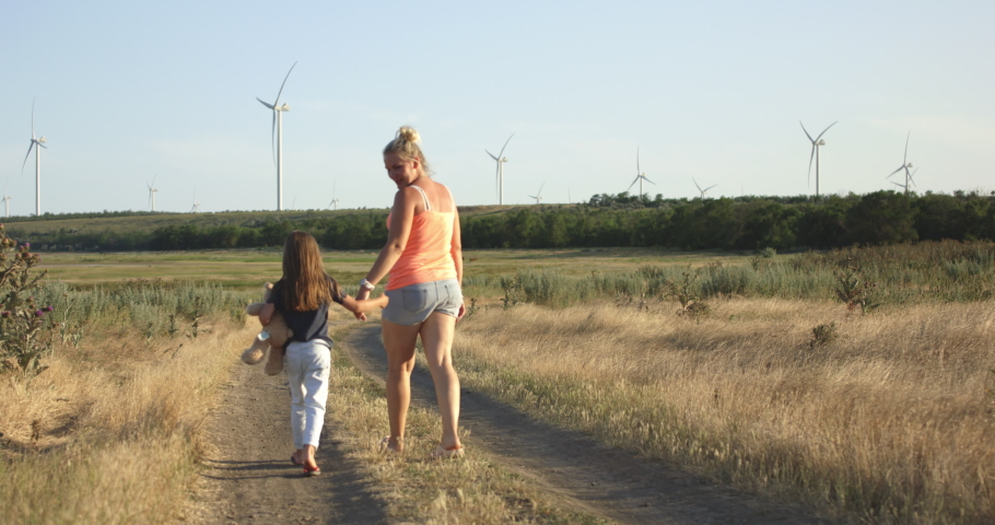Medium shot of mother and daughter walking then running on pathway | Shutterstock HD Video #1033322357
