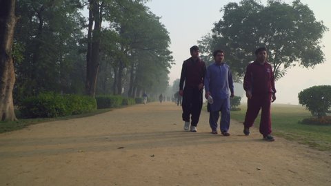 Faisalabad, Pakistan - 09 17 2018: People jogging on the track of a park in the morning