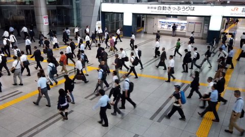 TOKYO, JAPAN - JULY 15TH, 2019. Time lapse footage of commuter crowd walking at Shinagawa train station. Panning to the right.