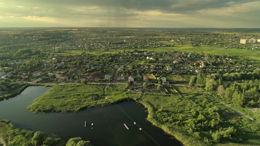 Country landscape in changing weather. Aerial shot of rural area. Sun and rainy clouds