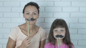 Mustache day. Surprised woman with kid in false mustache. - Powered by Shutterstock - Get 15% off with code: PIKWIZARD15
