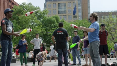 NEW YORK - MAY 31, 2015: entertainers in Washington Square Park, jugglers juggling, crowd watching, tourists, people, 4K slow motion, NY. Greenwich Village is a famous neighborhood in Manhattan NYC