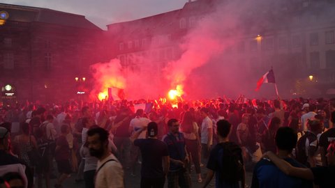 STRASBOURG, FRANCE - JULY 15 2018: Red distress flares with happiness and jubilation of supporters after the victory of the French team in the final of the World Cup football in Russia against Croatia