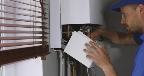 maintenance and repair service engineer working with house gas heating boiler
