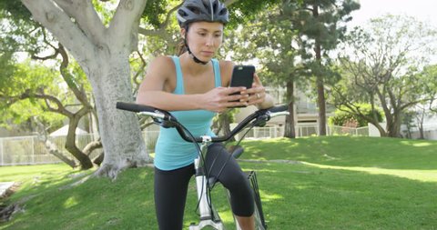 Woman cyclist texting on phone