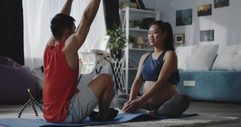 Full shot of a young man instructing a pregnant woman during workout