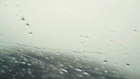 Close up of rain drops and condensation on the windscreen of a moving car