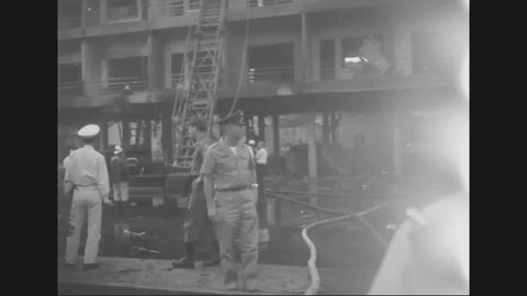 CIRCA 1964 - Fire fighters are seen on the job at the Brink BOQ in Saigon, which has been bombed by terrorists.