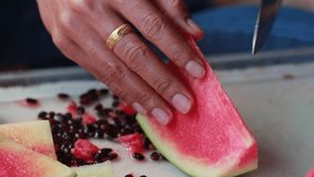 woman's hands using a knife peeling fruit, cut a watermelon in pieces place on the dish with fluently.
