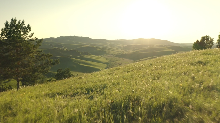 Aerial Drone Footage View: Flight over autumn mountain village with forests, fields and river in sunrise soft light. Majestic landscape. Beauty world. 4K.