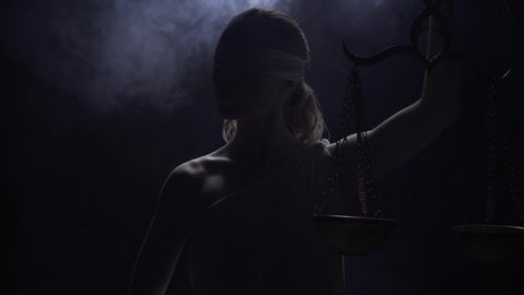 Greek goddess Themis is standing in the dark in the smoke with the scales, 4k