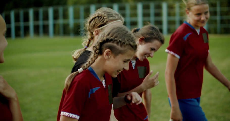 TRACKING Teenager kid girls soccer players talking and laughing after training. 4K UHD 60 FPS SLO MO | Shutterstock HD Video #1033416299