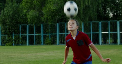 Стоковое видео: Young Caucasian teenager girl soccer football players heading the ball during practice session. 4K UHD