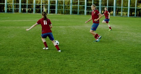 TRACKING Caucasian teenager girl soccer football team scoring a goal against opposing team. 4K UHD 60 FPS SLOW MOTION