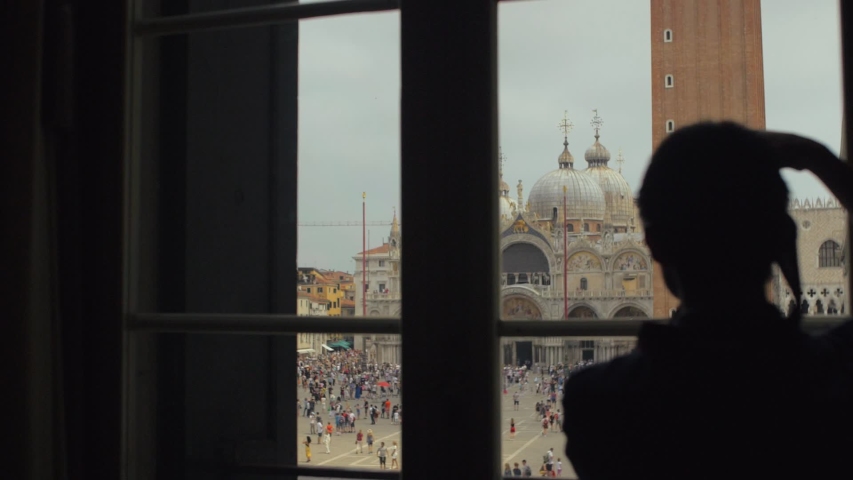 Unrecognizable athletic looking out of window. Handsome young guy enjoying St. Mark