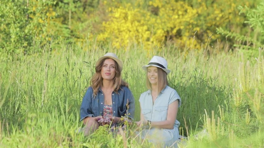 Two women celebrate by playfully tossing flowers in the air
