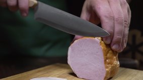 Close up video of tasty natural ham is sliced by sharp knife on the wooden board, jerky smoked meat, making of the sandwich with sliced ham, meat cooking, at the butcher shop, Full HD Prores HQ 422
