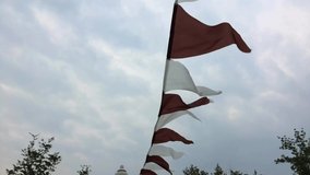 Brown and white triangle flags on the wind in a stormy weather