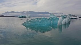 View from flying drone of floating of blue icebergs in Jokulsarlon Glacier Lagoon. Amazing summer morning in Vatnajokull National Park, Iceland, Europe. 4K video (Ultra High Definition).
