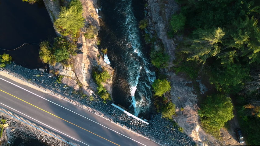Aerial shot: camera tilt along creek revealing beautiful northern landscape with multiple small lakes and endless boreal coniferous forest going over horizon. Six Mile Lake, Northern Ontario, Canada.