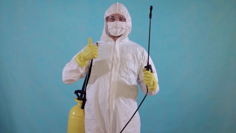 pest control worker in overalls with spray showing thumbs up