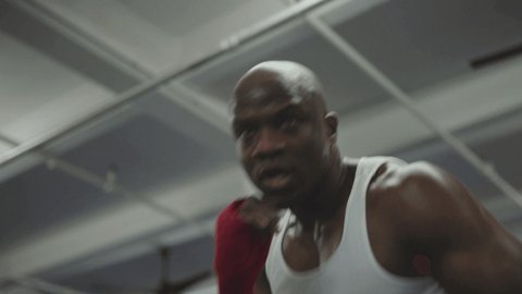 Male boxer training for a hard fight in boxing ring