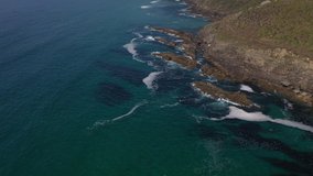 sea waves crashing against a rocky shore top view from the drone 4k video