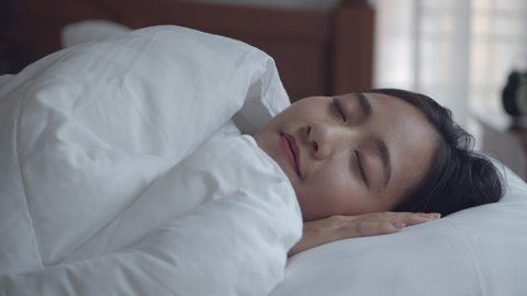Young Asian women sleeping well in comfortable in the bedroom at home.