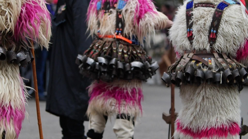 Bulgarian kukers in wool costumes dancing in slow motion with heavy bells on the waist and making the wool strands bounce.