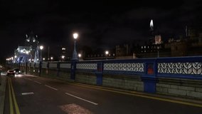 People Walking and Cars Driving on a Bridge in London, UK. Video Taken at Night time. The Old Fashion UK Lights, Light up the Street.