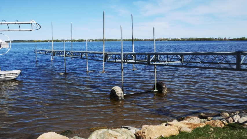 A boat dock on wheels is being pushed out into the lake during installation on a beautiful lake in Minnesota.