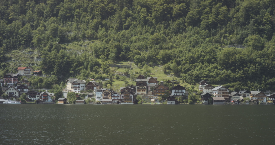 The lake and the shoreline houses on the backdrop of the forest. Hallstatt in Austria.
