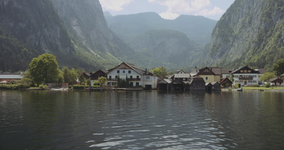 The small Austrian city of Hallstatt Village with the big mountains, small houses and the reflective natural lake. Slowmo.