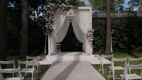 Wedding arch, chairs for guests, wedding accessories and decorations. Wedding ceremony. Beautiful wedding setup.