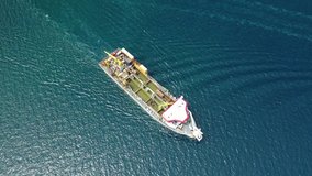 Aerial top view video of industrial poluted water sewage tanker cruising in Mediterranean destination