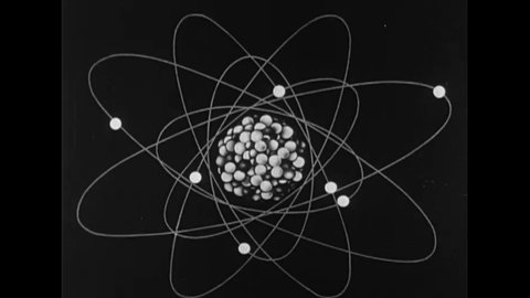CIRCA 1950s - Protons and neutrons are shown in the nucleus of an atom and an atomic weight is measured in an animation.
