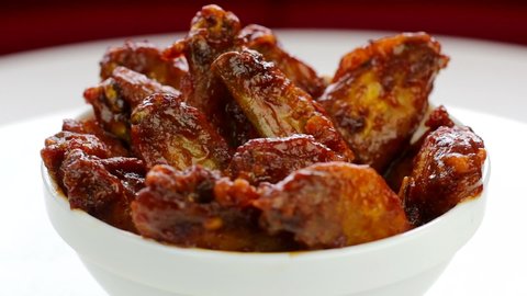 Bowl of buffalo wings with red and spicy sauce 