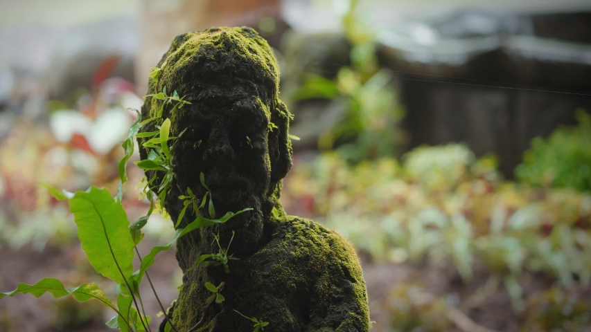 Small statue covered in moss. Ubud, Bali, Indonesia