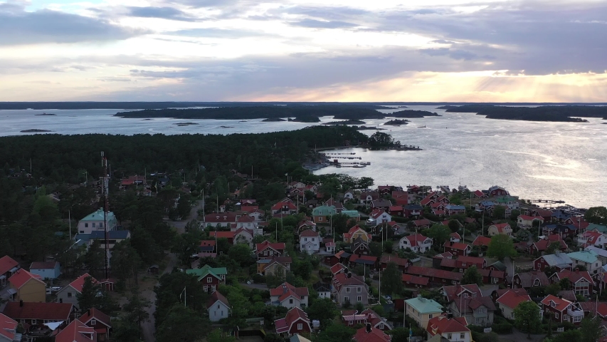 Aerial pan across the picturesque town of sandhamn on the Stockholm archipelago at dusk with a beautiful sunset