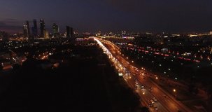 4K early night aerial video of busy road traffic with background view of high-rise buildings and memorial complex in Moscow, Russia